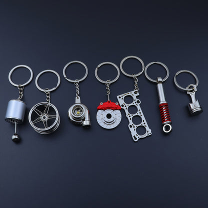 🗝️ 7-częściowy zestaw breloków tuningowych – Piston, Turbo, Wheel Hub, Gear Shift, Shock Absorber, Brake Disc, Engine Block – czarny, zinc alloy