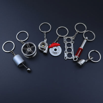 🗝️ 7-częściowy zestaw breloków tuningowych – Piston, Turbo, Wheel Hub, Gear Shift, Shock Absorber, Brake Disc, Engine Block – czarny, zinc alloy