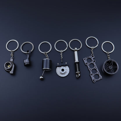 🗝️ 7-częściowy zestaw breloków tuningowych – Piston, Turbo, Wheel Hub, Gear Shift, Shock Absorber, Brake Disc, Engine Block – czarny, zinc alloy