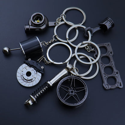 🗝️ 7-częściowy zestaw breloków tuningowych – Piston, Turbo, Wheel Hub, Gear Shift, Shock Absorber, Brake Disc, Engine Block – czarny, zinc alloy