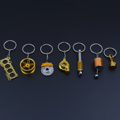 🗝️ 7-częściowy zestaw breloków tuningowych – Piston, Turbo, Wheel Hub, Gear Shift, Shock Absorber, Brake Disc, Engine Block – czarny, zinc alloy